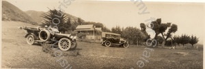 Image of Two cars parked in front of a house