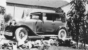 Image of Andrew P. Hill, Jr. standing next to a car in front of the house